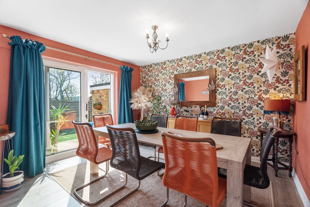 Dining room with colourful styling and patio doors facing the garden